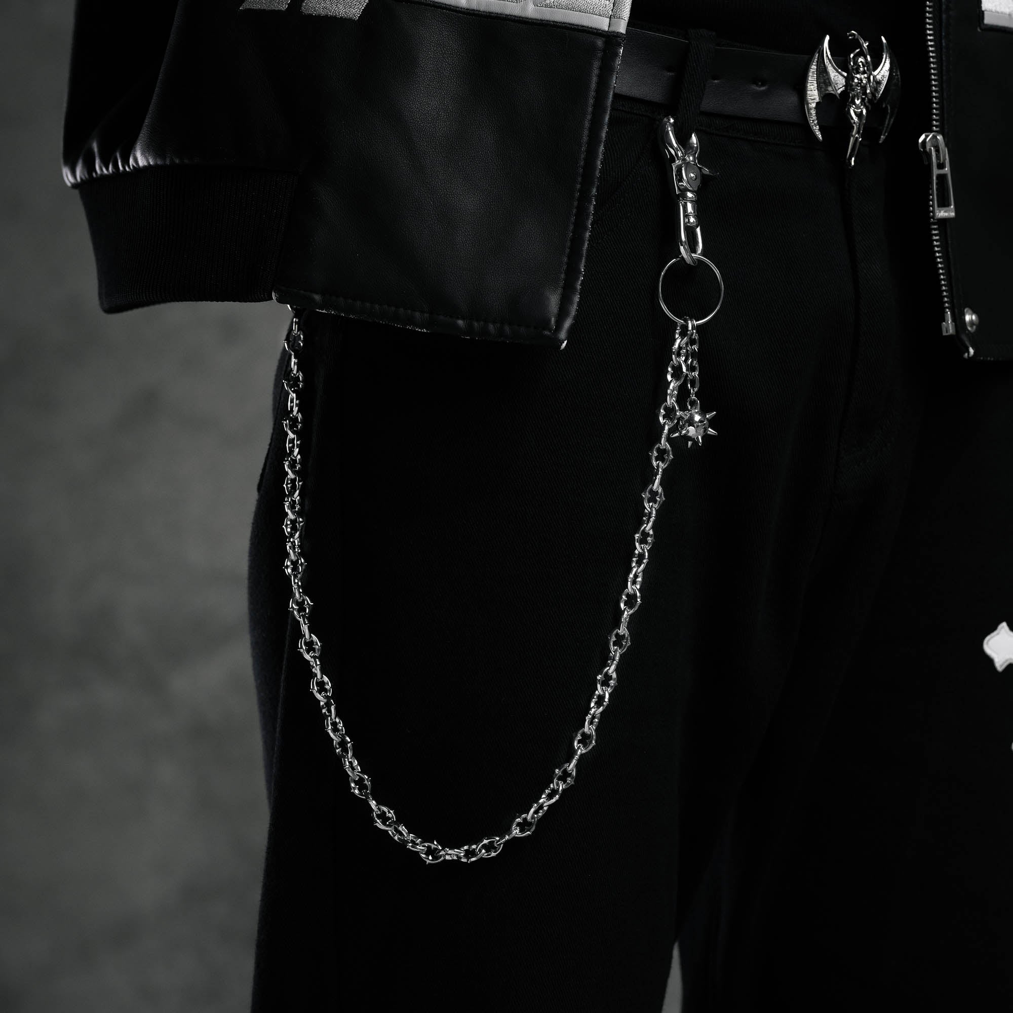 9mm spiked cable link wallet chain featuring spiked ball charm on cable link chain on black pants next to pocket under black leather jacket