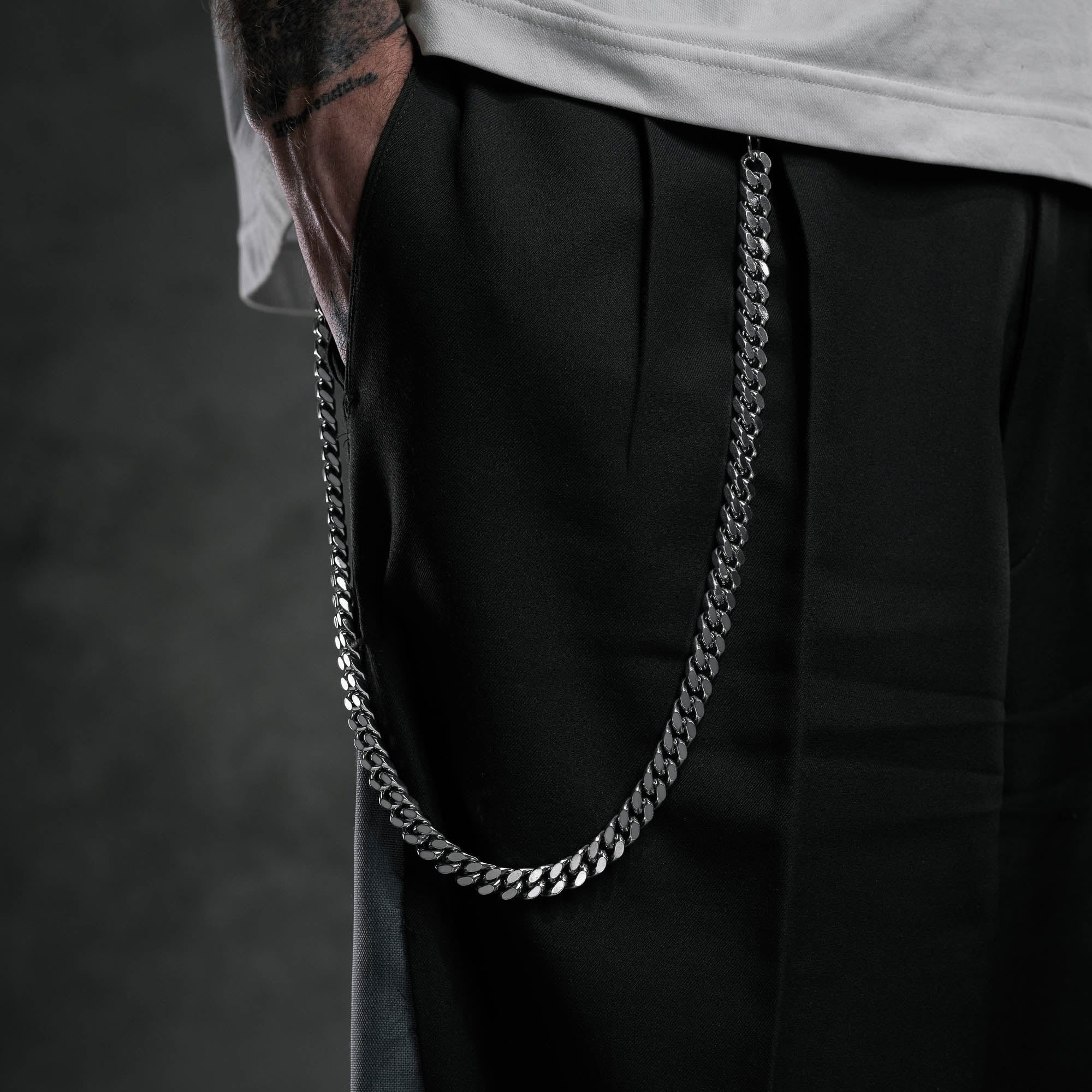 silver cuban link wallet chain on body beside pocket 