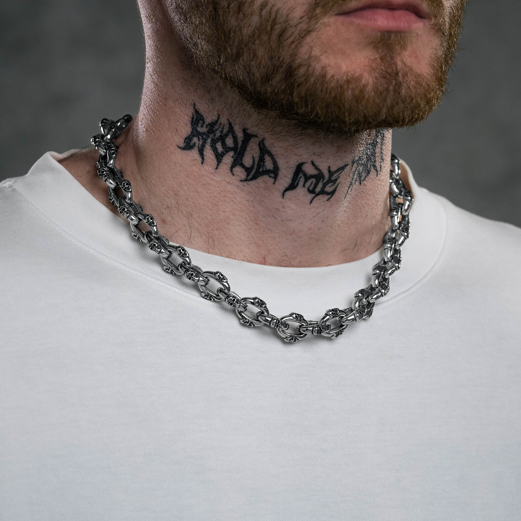 Silver Skull chain on male model with neck tattoo