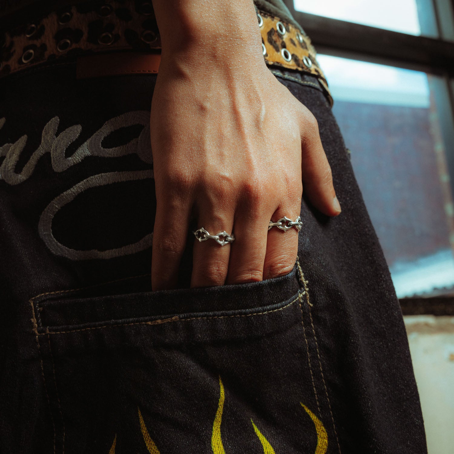 Sterling silver ring with spiked cable links on male model putting his hand in his pocket 