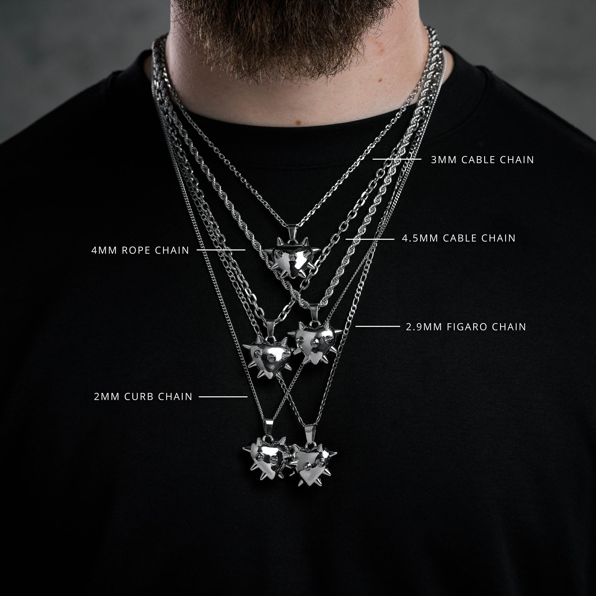 multiple spiked heart pendants on multiple link style chains on male neck black t shirt