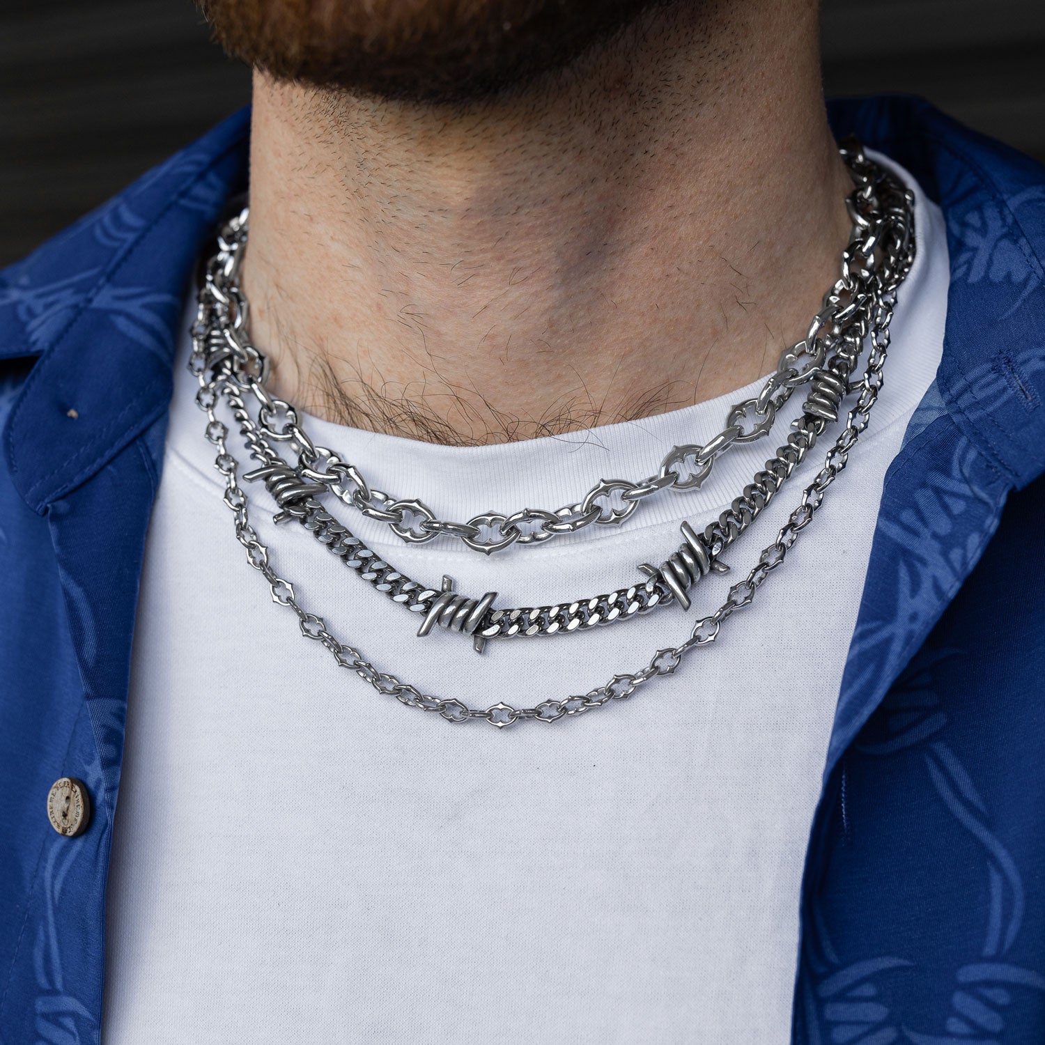Gothic silver chain set with spiked and barbed wire jewelry on mans neck by statement collective 