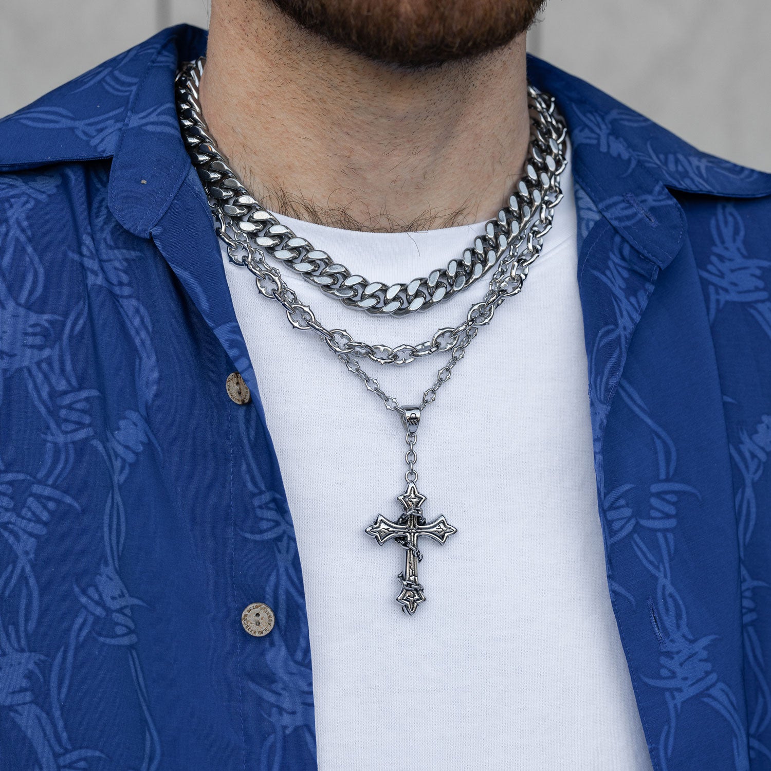 Gothic silver necklace set with spiked chain and cross pendant on mans neck by statement collective